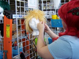 A stylist from Arda Wigs Canada works her magic on a wig in the dealer's room.